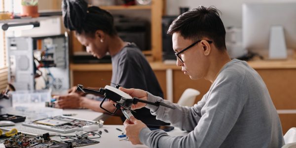 biracial-colleagues-repairing-electronic-devices-in-workshop-1.jpg