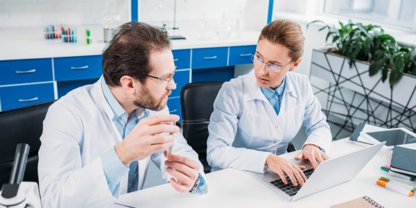 scientific-researchers-in-white-coats-discussing-work-at-workplace-in-laboratory-1.jpg